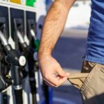 Energy Crisis Wrecks Wallets — Prices Soar! Person at a gas station showing empty pockets