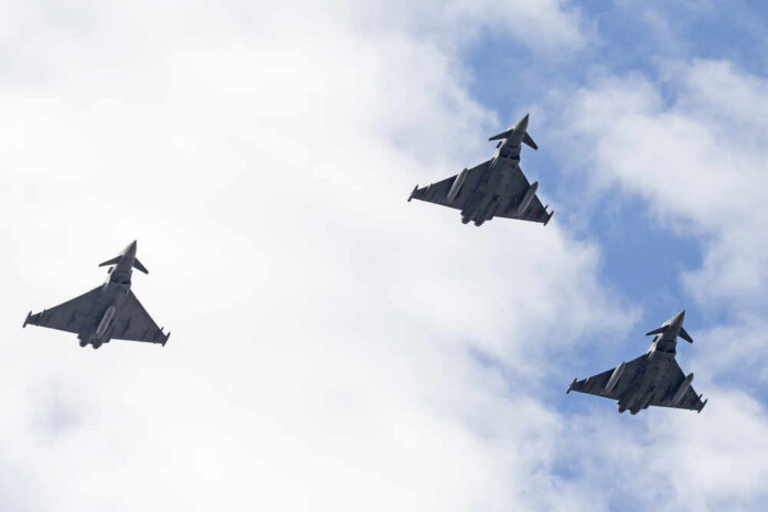 shutterstock_352414064.jpg Three fighter jets flying in formation against a cloudy sky