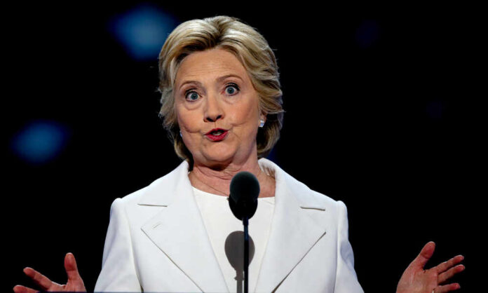 shutterstock_1060935611.jpg A woman in a white suit speaking at a podium during a conference