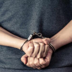 Vicious Animal Cruelty: Man Faces 31 Years Hands in handcuffs, showing a clenched fist