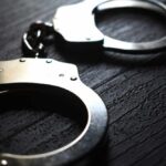 Checkpoint Gunfire Freezes Washington Hilton Close-up of metallic handcuffs on a textured surface