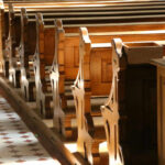 Gen Z FLOODS Churches—Boomers Left Behind Interior of a church featuring wooden pews and natural light streaming in
