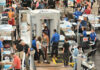 Busy airport security checkpoint with passengers being screened