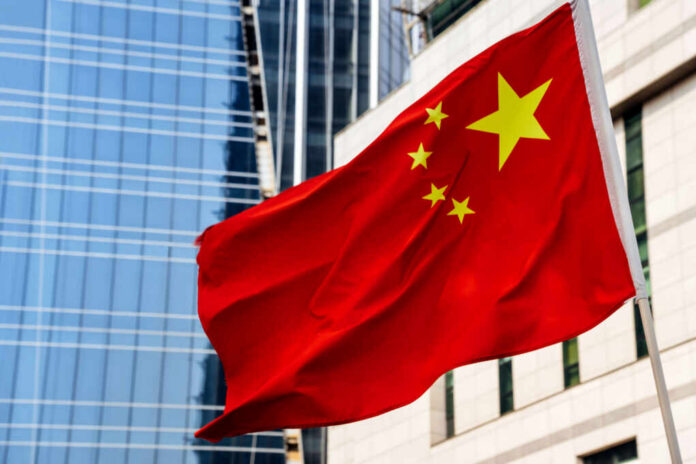 Chinese flag waving in front of modern buildings