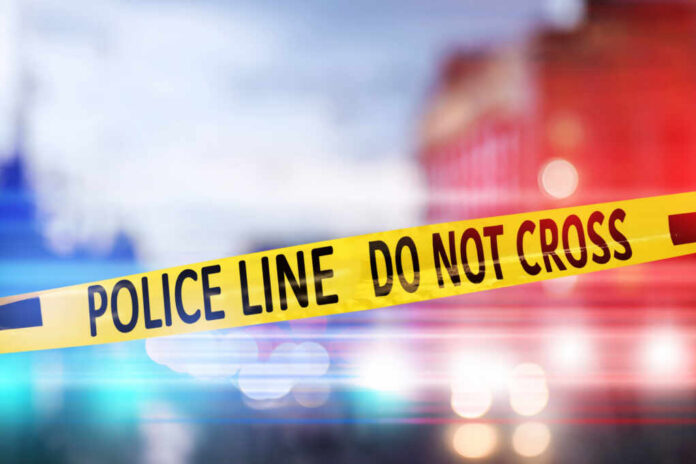 shutterstock_1899490510.jpg Yellow police tape reading DO NOT CROSS at a crime scene