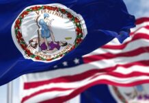Virginia state flag waving in the foreground with an American flag in the background