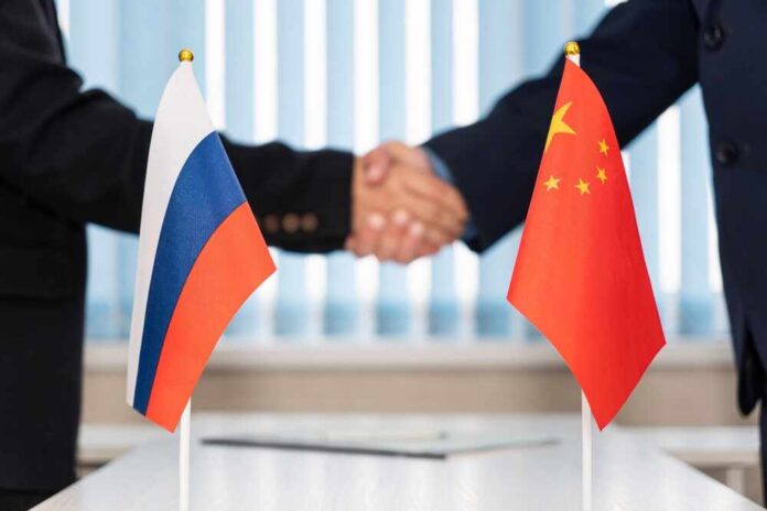 Handshake between two individuals with Russian and Chinese flags in the foreground