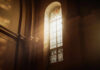 Sunlight streaming through a stained glass window in a church