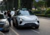 An autonomous vehicle on a city street with people nearby