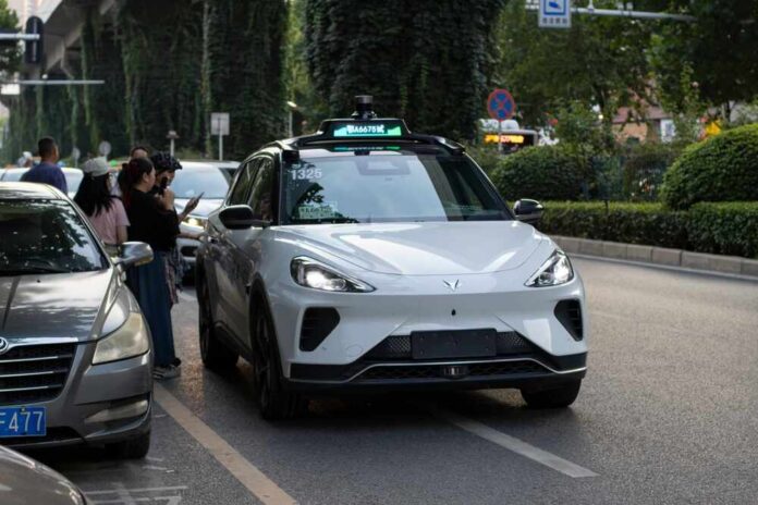 An autonomous vehicle on a city street with people nearby