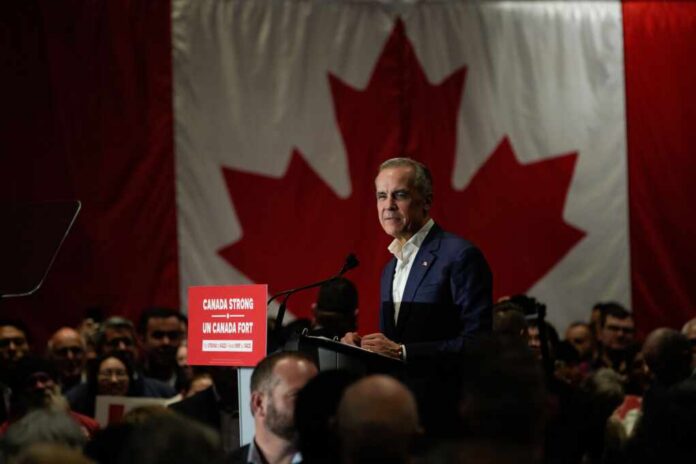 A speaker addressing an audience in front of a large Canadian flag