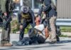 Federal Agents Storm MacArthur Park, Arrest 18 Police officers apprehending a suspect on the ground