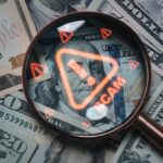 Magnifying glass over U.S. dollar bills with a scam warning