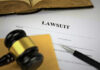 Judge Torches Epstein Cover-Up? A gavel resting on a legal document titled 'LAWSUIT' with a pen and an open book in the background