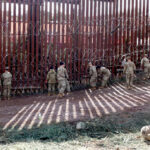 Border Calm Hinges On Tehran’s Militia Military personnel working on a border fence with barbed wire