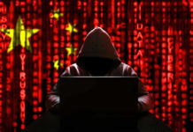 Foreign Grip On France’s Spies A hooded figure sitting in front of a laptop with a red digital background