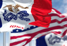 Iowa state flag prominently displayed with other flags in the background