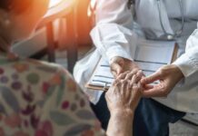 Statin Side Effects Masquerading As Menopause? A doctor holding the hand of an elderly patient during a consultation