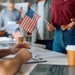 People participating in a voting event with American flags and paperwork