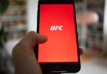 Hand holding smartphone with red app screen