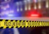 Yellow police tape reading 'DO NOT CROSS' at a crime scene