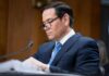 Bolton Bombshell Ignites Deep State Fury Individual in a suit reviewing documents during a senate hearing
