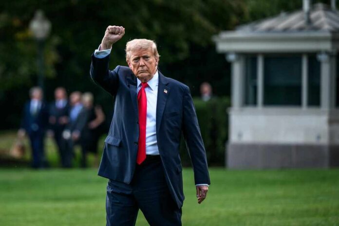 A political figure walking outdoors with a raised fist