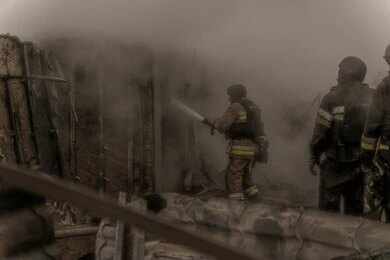 2620121737 Firefighters spray water into a smoke-filled structure