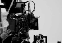Close-up of a film camera with various cables and equipment in a studio setting