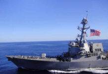 GAO Slams Navy’s Missile Moonshot A naval destroyer sailing in the ocean with an American flag