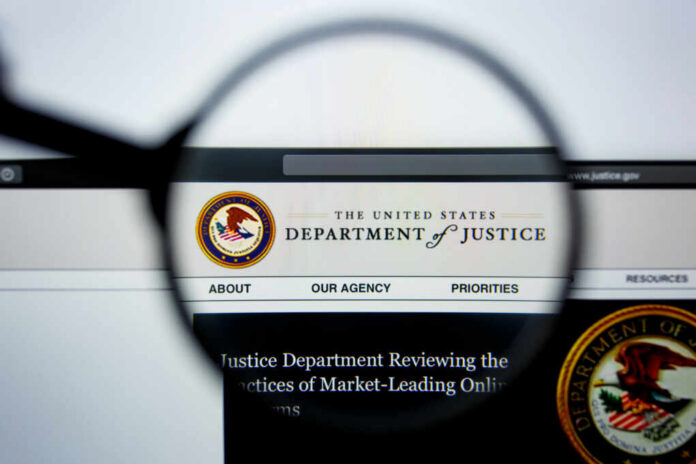 shutterstock_1466142779 Close-up view of the Department of Justice website through a magnifying glass