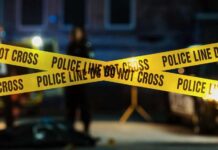 Killarney Murder Ignites Ireland Panic Police tape marking a crime scene with blurred figures in the background