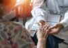 Jailhouse Imposter Rips Off Sick Veterans A doctor holding the hand of an elderly patient during a consultation
