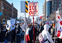Minnesota Panic Spins Into Culture War Crowd of protesters holding signs at a rally against ICE
