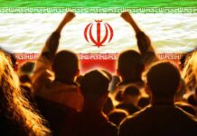 Iraq’s Power Funeral Goes Mega Crowd of people raising their fists in front of the Iranian flag