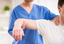 Deadly Lump Dismissed As ‘Strain’ Physical therapist guiding a patient's arm during shoulder exercise