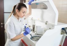Lab technician using an analyzer with a pipette
